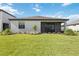 Well-manicured backyard featuring green grass, landscaping, and a screened-in lanai at 15127 Oxford Grey Dr, Bradenton, FL 34211
