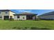 Exterior rear view of the home with a screened in lanai, tidy landscaping, and lush green lawn at 15127 Oxford Grey Dr, Bradenton, FL 34211