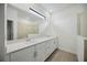 Modern bathroom with dual sinks, white cabinets, a large mirror and recessed lighting at 15127 Oxford Grey Dr, Bradenton, FL 34211