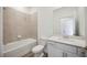Bright bathroom featuring a tub with tile surround and white vanity with framed mirror at 15127 Oxford Grey Dr, Bradenton, FL 34211