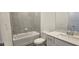 Well-lit bathroom with a tub-shower combo, neutral tile, and modern fixtures at 15127 Oxford Grey Dr, Bradenton, FL 34211