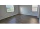 Bright bedroom with hardwood floors and two windows allowing ample natural light at 15127 Oxford Grey Dr, Bradenton, FL 34211