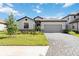 Charming single-story home with a well-manicured lawn and a paved driveway leading to a two-car garage at 15127 Oxford Grey Dr, Bradenton, FL 34211