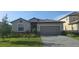 Charming one-story home featuring a manicured lawn, brick driveway, and two car garage at 15127 Oxford Grey Dr, Bradenton, FL 34211