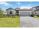 Attractive home with a two-car garage, green lawn, and a brick-paved driveway, offering a welcoming curb appeal at 15127 Oxford Grey Dr, Bradenton, FL 34211