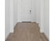 Bright hallway featuring modern wood-look tile flooring, white trim, and a closed door at the end of the hallway at 15127 Oxford Grey Dr, Bradenton, FL 34211