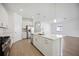 Open kitchen with island flows into living area with stainless appliances and white cabinets at 15127 Oxford Grey Dr, Bradenton, FL 34211