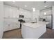 Modern kitchen featuring white cabinets, stainless steel appliances, quartz countertops, and wood-look tile flooring at 15127 Oxford Grey Dr, Bradenton, FL 34211