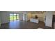 Open-concept living space with hard floors, a modern kitchen, and sliding doors to the backyard at 15127 Oxford Grey Dr, Bradenton, FL 34211