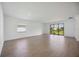 Expansive living room with wood-look tile floors, large windows, and natural light streaming in, airy and bright at 15127 Oxford Grey Dr, Bradenton, FL 34211