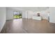 Open-concept living space with wood-look tile flooring seamlessly connecting the living room, kitchen, and dining area at 15127 Oxford Grey Dr, Bradenton, FL 34211