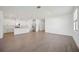 Spacious open-plan area featuring modern kitchen with white cabinets, stainless appliances, and wood-look tile floors at 15127 Oxford Grey Dr, Bradenton, FL 34211