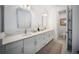 Bright bathroom featuring double vanity with modern hardware, mirrors, and a commode at 17737 Savory Mist Cir, Bradenton, FL 34211