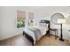Stylish bedroom featuring natural light, hardwood floors, and a modern lamp at 17737 Savory Mist Cir, Bradenton, FL 34211