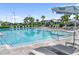 Expansive community pool with comfortable lounge chairs, umbrellas, and tables with seating at 17737 Savory Mist Cir, Bradenton, FL 34211
