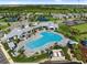 An aerial view shows a luxurious community pool surrounded by lush landscaping and seating at 17737 Savory Mist Cir, Bradenton, FL 34211