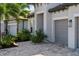 Close up view of a home's exterior featuring an attached two-car garage, lush landscaping, and paved driveway at 17737 Savory Mist Cir, Bradenton, FL 34211
