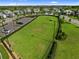 Aerial view of a large green space with surrounding homes and a nearby parking lot at 17737 Savory Mist Cir, Bradenton, FL 34211