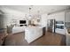 Open-concept kitchen and living area featuring stainless steel appliances and modern white cabinets at 17737 Savory Mist Cir, Bradenton, FL 34211