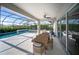 Covered patio with a dining area and scenic views of the screened-in pool at 17737 Savory Mist Cir, Bradenton, FL 34211
