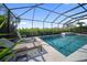 This backyard features a screened-in pool with lush landscaping and lounge chairs at 17737 Savory Mist Cir, Bradenton, FL 34211