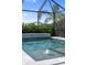 A screened-in pool featuring an elevated waterfall and integrated spa at 17737 Savory Mist Cir, Bradenton, FL 34211