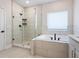 Elegant bathroom with a soaking tub, glass-enclosed shower, and sleek, modern fixtures at 2217 Muesel St, Sarasota, FL 34237