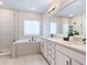 Modern bathroom featuring a soaking tub, walk-in shower, and double sink vanity with clean, bright finishes at 2217 Muesel St, Sarasota, FL 34237