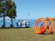 Scenic bayfront view with artists at work and a vibrant orange sculpture on the grassy shore at 2217 Muesel St, Sarasota, FL 34237