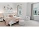 Sunlit bedroom with a comfortable bed, soft pink throw, and two large windows at 2217 Muesel St, Sarasota, FL 34237