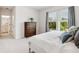Bright bedroom with white linens, a wooden dresser, and large windows with a green view at 2217 Muesel St, Sarasota, FL 34237