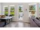 Bright dining area with large windows and modern decor next to a sliding glass door and comfortable couch at 2217 Muesel St, Sarasota, FL 34237