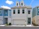 Charming two-story home with a clean white facade, complemented by a blue door and integrated garage at 2217 Muesel St, Sarasota, FL 34237