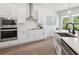 Modern kitchen with white cabinets, island and stainless steel appliances with natural lighting and dark faucet at 2217 Muesel St, Sarasota, FL 34237