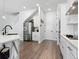 Kitchen area with stainless steel appliances, white cabinets, a stair case, and luxury vinyl plank flooring at 2217 Muesel St, Sarasota, FL 34237