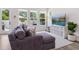 Bright, modern living room with hardwood floors, a plush sectional couch, and large windows overlooking the backyard at 2217 Muesel St, Sarasota, FL 34237