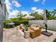 Backyard patio area with outdoor seating, an umbrella, a grill, and a green lawn under a blue sky at 2217 Muesel St, Sarasota, FL 34237