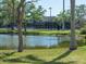 Picturesque view of a pond and tennis courts with mature trees, landscaping, and an egret at 2217 Muesel St, Sarasota, FL 34237