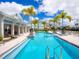 Inviting community pool with palm trees and modern lounging areas, surrounded by colorful buildings at 2217 Muesel St, Sarasota, FL 34237