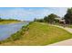 Scenic waterfront view of a canal featuring people biking along a path under a blue sky with clouds at 2217 Muesel St, Sarasota, FL 34237