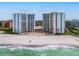 Gorgeous aerial view of waterfront condos featuring a pristine beach and the clear ocean waters at 2295 Gulf Of Mexico Dr # 64S, Longboat Key, FL 34228
