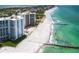 Stunning aerial view of beachfront condos with a pool and direct access to the beach and Gulf of Mexico at 2295 Gulf Of Mexico Dr # 64S, Longboat Key, FL 34228