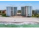 Beautiful aerial shot of the condo building, the beach, and the surrounding ocean waters on a sunny day at 2295 Gulf Of Mexico Dr # 64S, Longboat Key, FL 34228