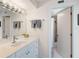 Clean bathroom features a shower and a sink with storage and simple decor at 2295 Gulf Of Mexico Dr # 64S, Longboat Key, FL 34228