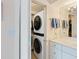 Modern bathroom features a stackable washer/dryer and simple white decor at 2295 Gulf Of Mexico Dr # 64S, Longboat Key, FL 34228