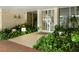 Entrance to the building with potted plants along a brick walkway and a glass entryway at 2295 Gulf Of Mexico Dr # 64S, Longboat Key, FL 34228