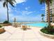 Community pool overlooking the ocean with palm trees and lounge seating at 2295 Gulf Of Mexico Dr # 64S, Longboat Key, FL 34228