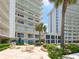 Exterior view of beachfront condos surrounded by lush landscaping and palm trees at 2295 Gulf Of Mexico Dr # 64S, Longboat Key, FL 34228