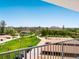 Bright exterior view from balcony overlooking a well-maintained green lawn, tree-lined streets, and some parked vehicles at 2295 Gulf Of Mexico Dr # 64S, Longboat Key, FL 34228