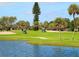 Picturesque golf course with manicured lawns and a tranquil pond in a lush, tropical setting at 2295 Gulf Of Mexico Dr # 64S, Longboat Key, FL 34228
